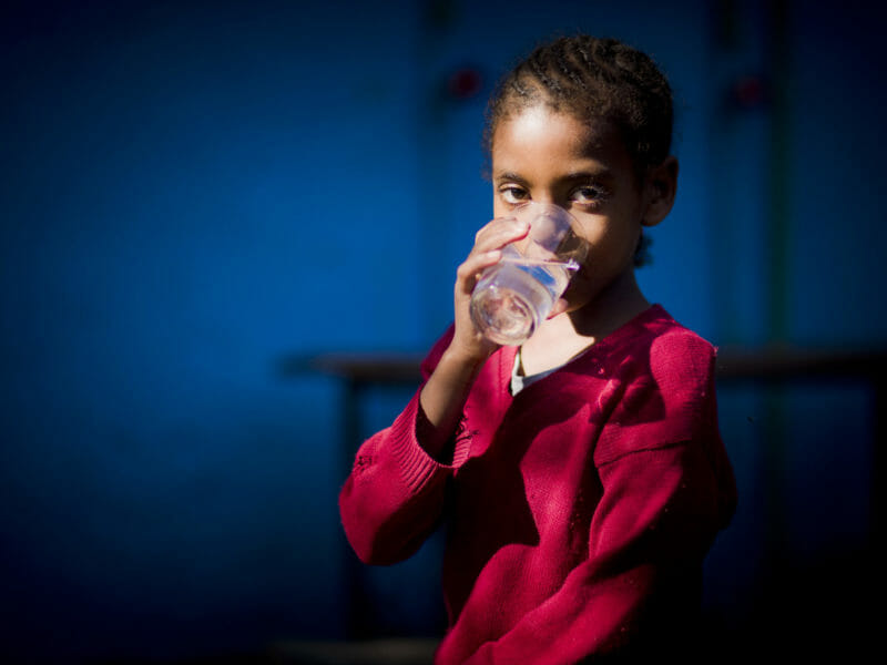 Schoolgirl with clean water, Tensae Birhan Primary School, Addis Ababa, Ethiopia